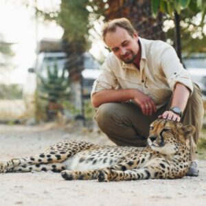 Cheetah encounter. A visitor experiencing a close, guided encounter with an ambassador cheetah at the Cheetah Outreach in Somerset West.